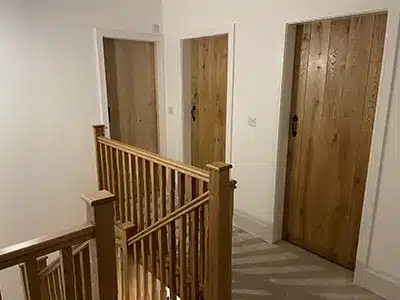 wooden-doors-top-of-staircase-bannister